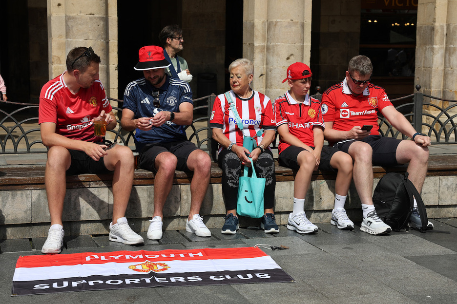 Una seguidora zurigorri entre aficionados del Manchester United, en la plaza Barria. Una seguidora zurigorri entre aficionados del Manchester United, en la plaza Barria.